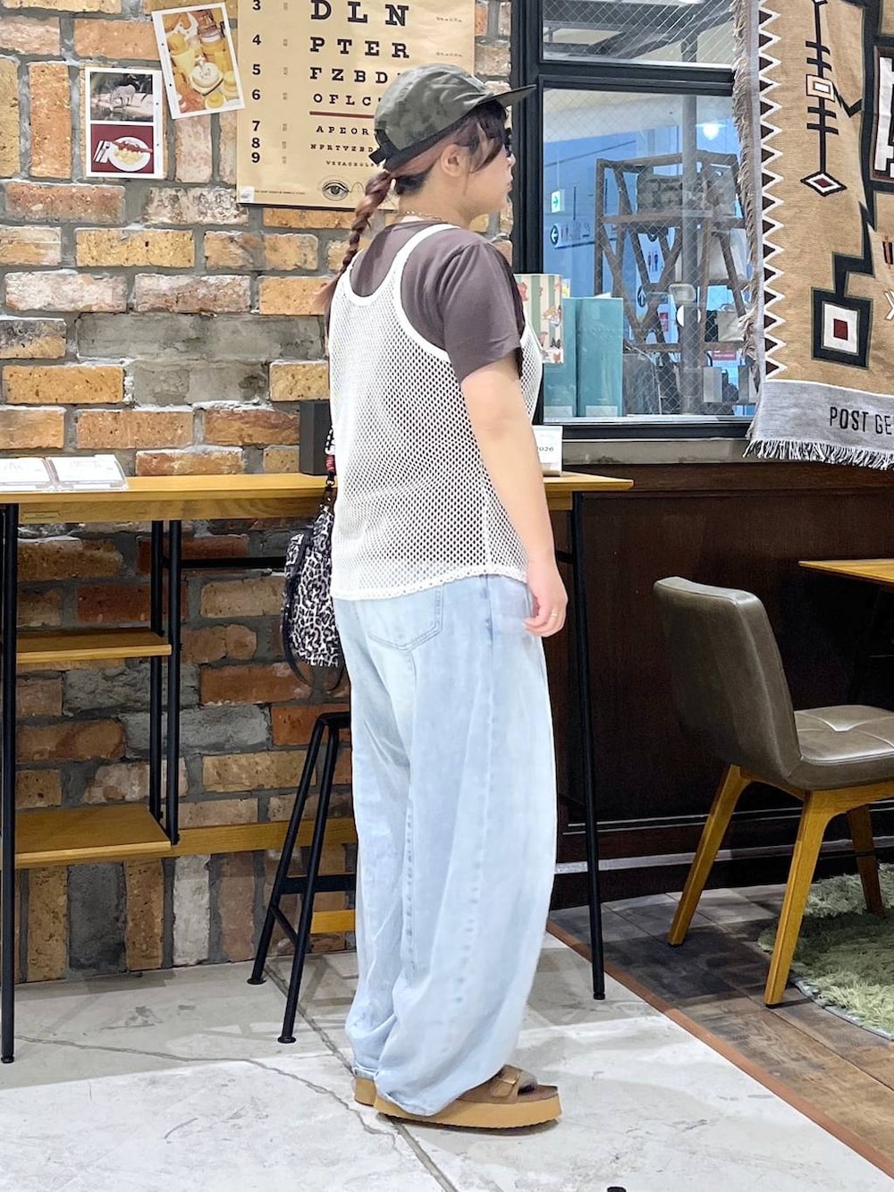ホワイト系のタンクトップ、ブラウン系のTシャツ/カットソー、ブルー系のデニムパンツを着用したレディースの夏コーディネートの6枚目の写真