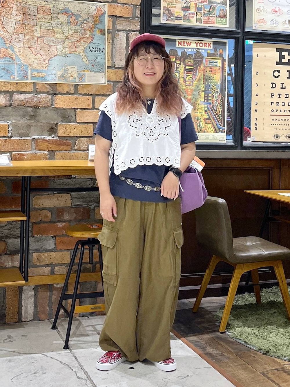 パープル系のトートバッグ、ホワイト系のベスト、ブルー系のTシャツ/カットソーを着用したレディースの夏コーディネートの3枚目の写真