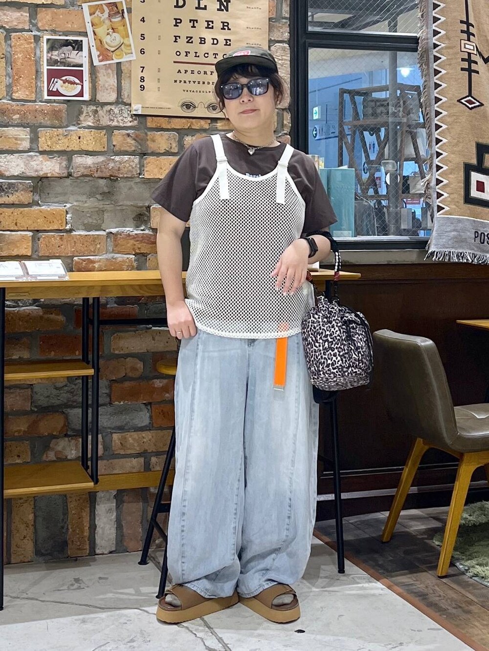 ホワイト系のタンクトップ、ブラウン系のTシャツ/カットソー、ブルー系のデニムパンツを着用したレディースの夏コーディネートの7枚目の写真