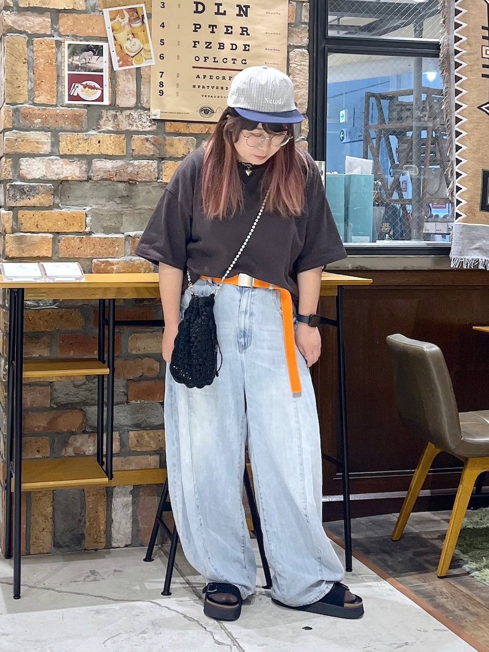 ブルー系のデニムパンツ、ブラウン系のTシャツ/カットソー、ブラック系のサンダルを着用したレディースの夏コーディネートの7枚目の写真