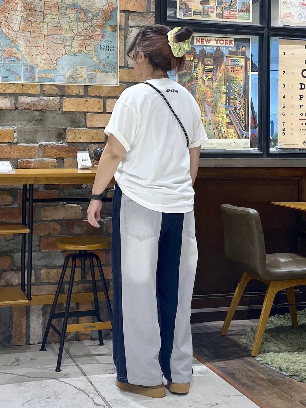 オレンジ系のショルダーバッグ、ブルー系のデニムパンツ、ブラウン系のサンダルを着用したレディースの夏コーディネートの4枚目の写真