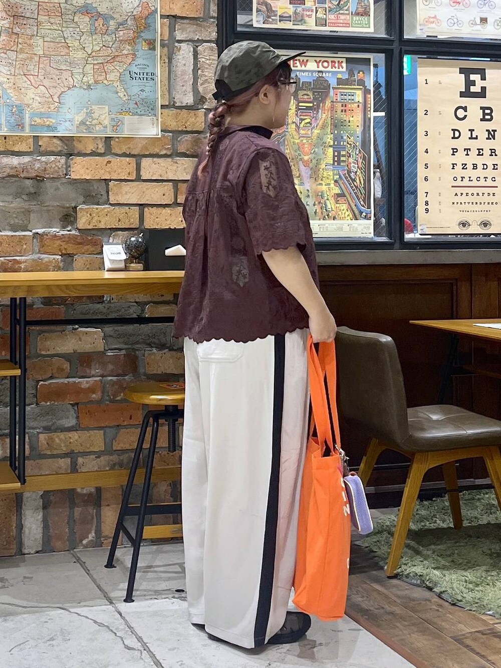 ブラウン系のその他パンツ、ブラウン系のシャツ/ブラウス、レッド系のトートバッグを着用したレディースの夏コーディネートの5枚目の写真