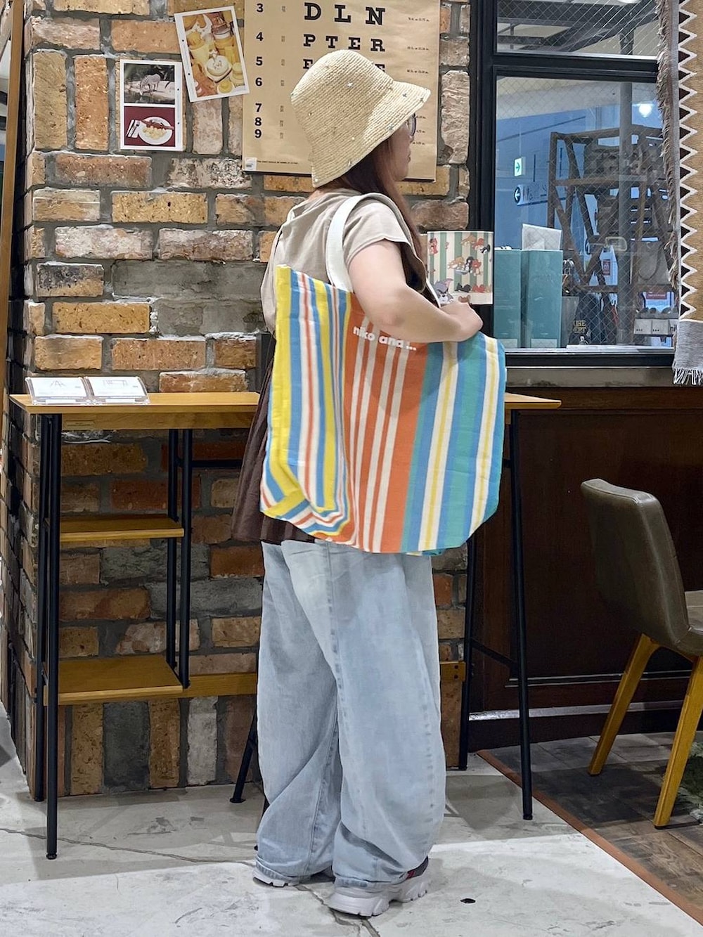 ブルー系のデニムパンツ、その他のスニーカー、レッド系のトートバッグを着用したレディースの夏コーディネートの6枚目の写真