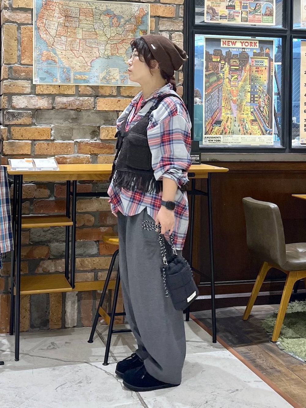 ブラウン系のベスト、レッド系のTシャツ/カットソー、ブラック系のモカシン/デッキシューズを着用したレディースの秋コーディネートの4枚目の写真