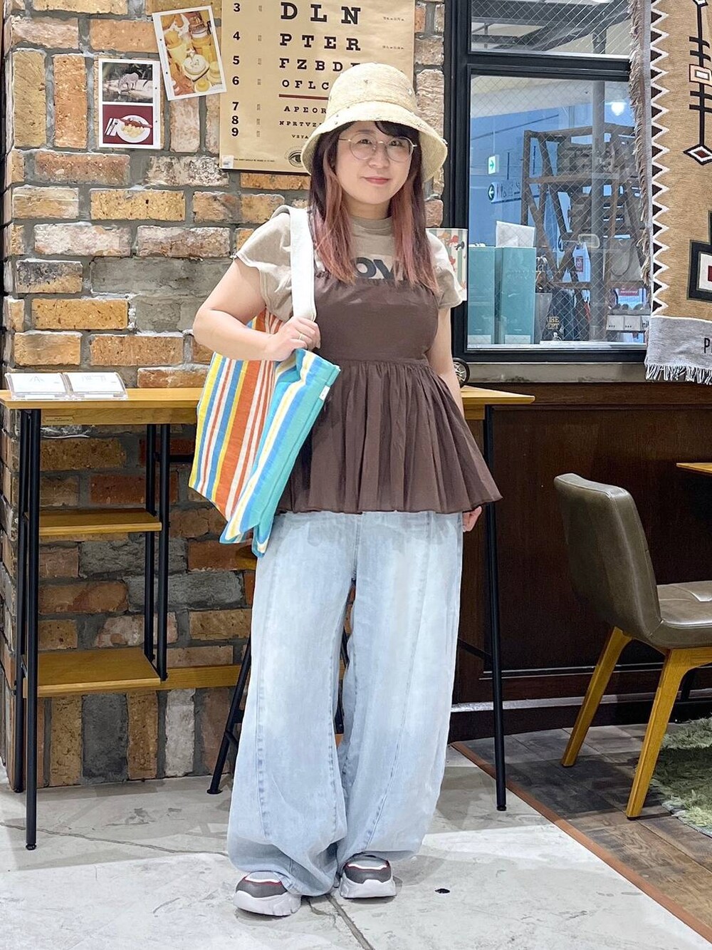 ブルー系のデニムパンツ、その他のスニーカー、レッド系のトートバッグを着用したレディースの夏コーディネートの3枚目の写真