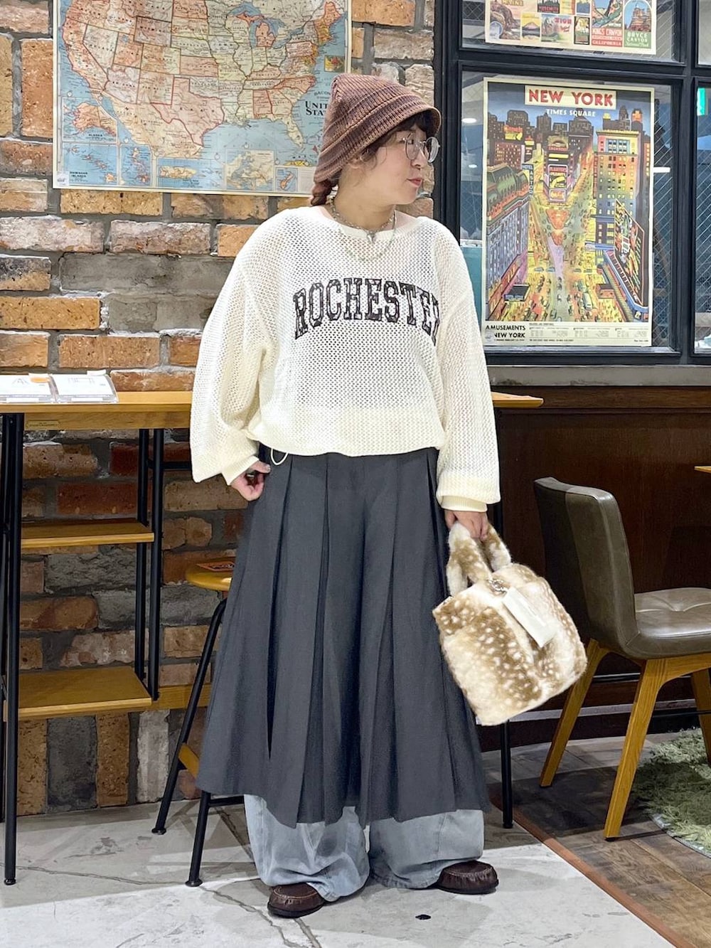 ブラウン系のローファー、ブルー系のデニムパンツ、ベージュ系のニット/セーターを着用したレディースの秋コーディネートの6枚目の写真