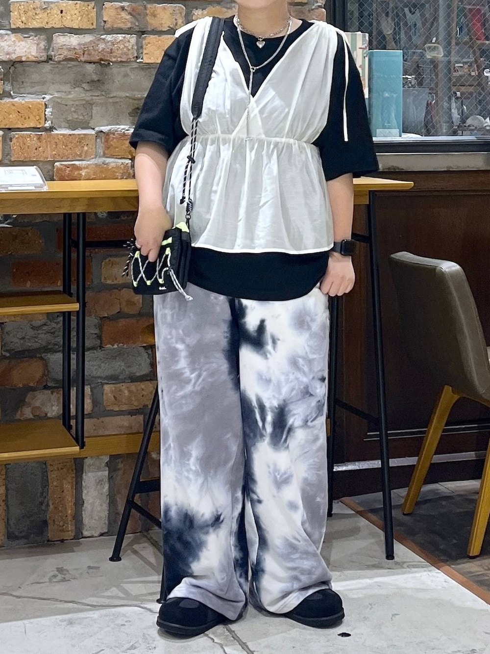 その他のTシャツ/カットソー、ブラック系のスニーカー、ブラック系のショルダーバッグを着用したレディースの夏コーディネートの2枚目の写真