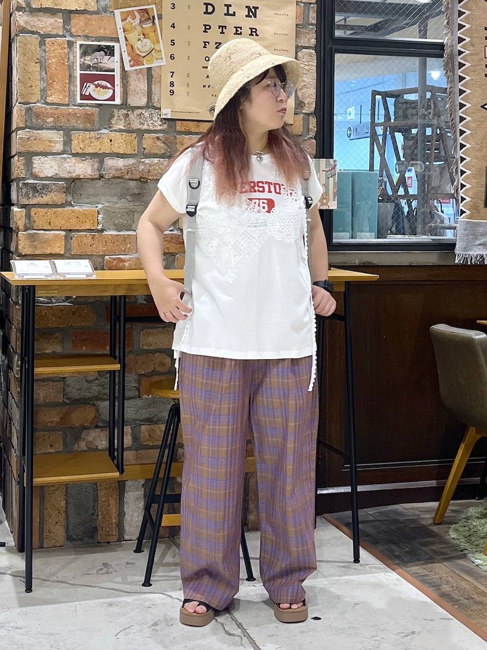 ブラック系のサンダル、ホワイト系のTシャツ/カットソー、グレー系のバックパック/リュックを着用したレディースの夏コーディネートの5枚目の写真