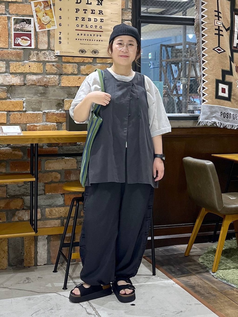 ブラック系のベスト、ブラック系のその他パンツ、ブラック系のサンダルを着用したレディースの夏コーディネートの3枚目の写真