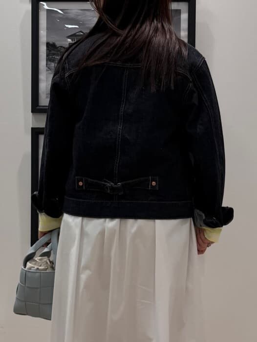ブルー系のデニムジャケット、ホワイト系のスカート、ブルー系のトートバッグを着用したレディースの冬コーディネートの5枚目の写真