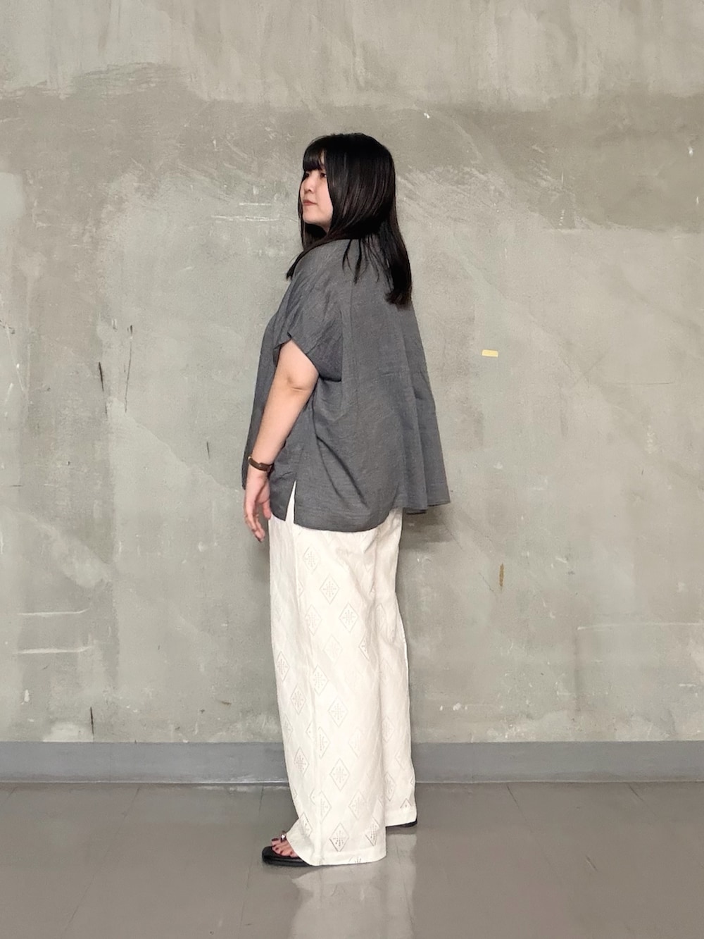 グレー系のシャツ/ブラウス、ホワイト系のその他パンツ、ブラック系のサンダルを着用したレディースの夏コーディネートの2枚目の写真