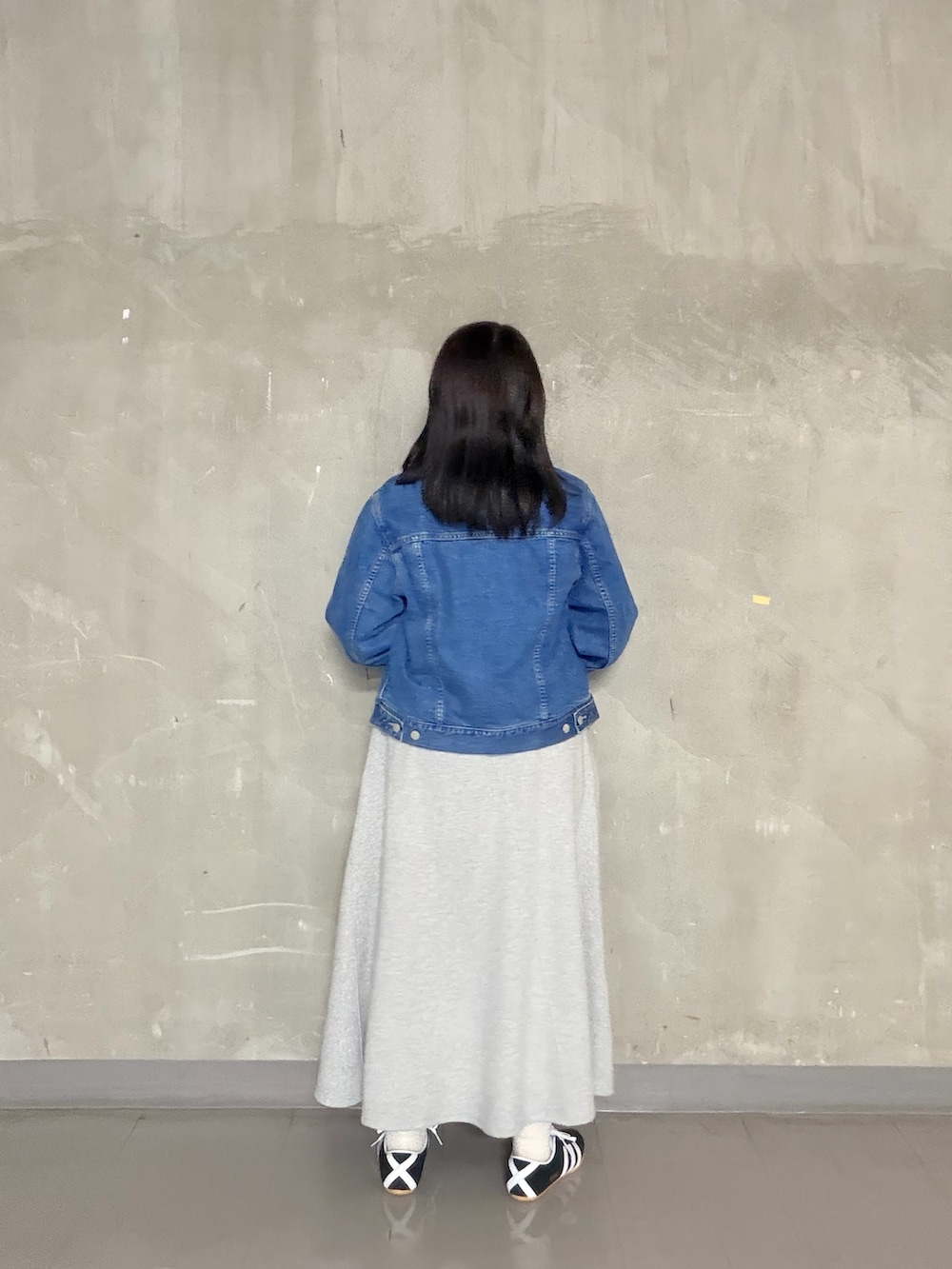 グレー系のスカート、イエロー系のTシャツ/カットソー、ブラック系のスニーカーを着用したレディースの春コーディネートの3枚目の写真