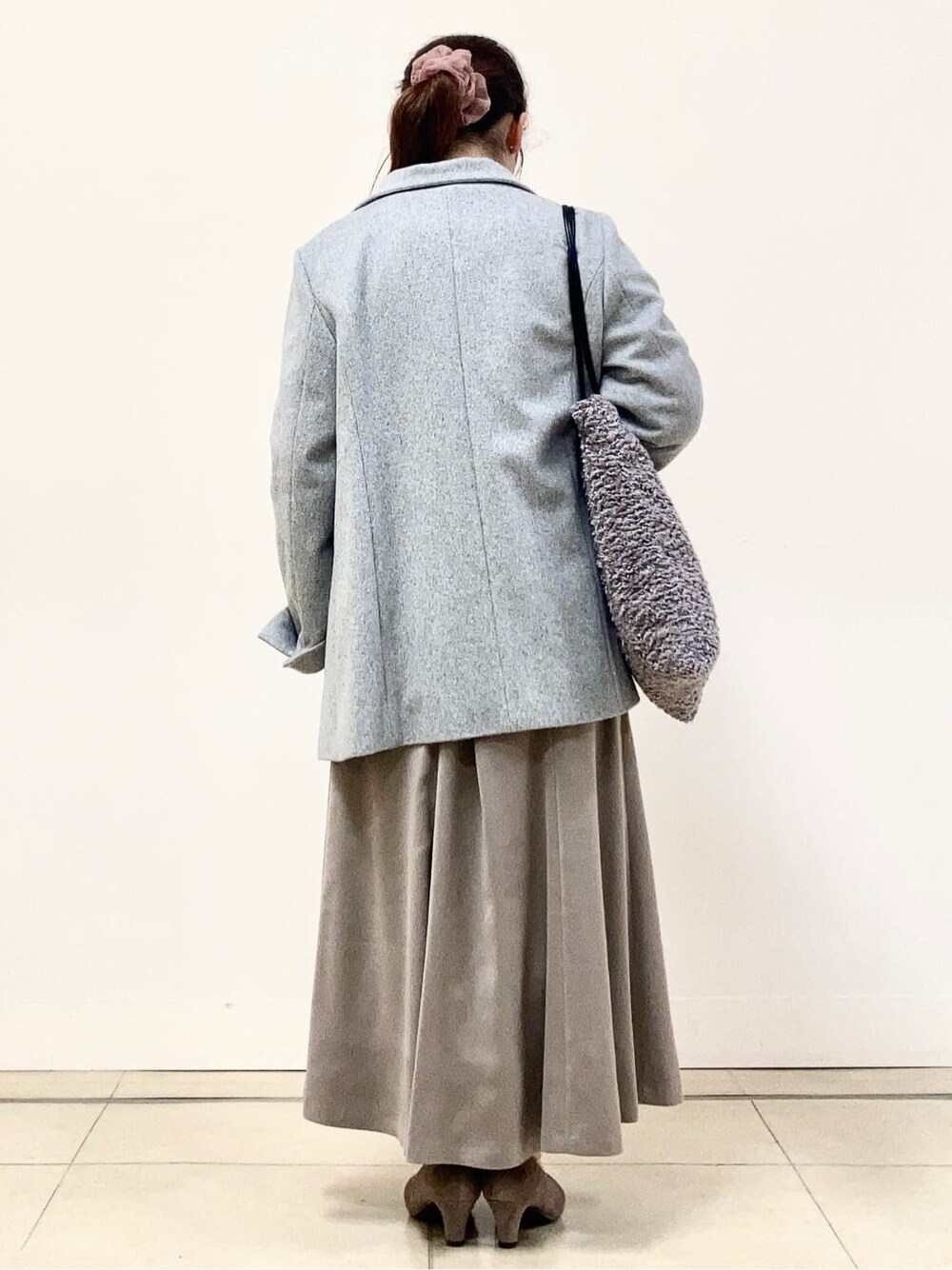 グレー系のその他アウター、グリーン系のニット/セーター、ベージュ系のスカートを着用したレディースの冬コーディネートの3枚目の写真