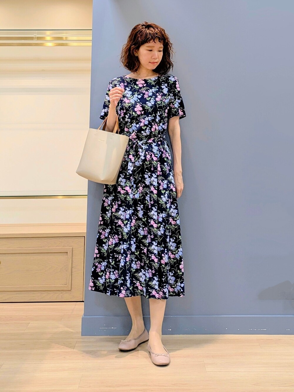 ブルー系のワンピース、ベージュ系のトートバッグを着用したレディースの夏コーディネートの6枚目の写真
