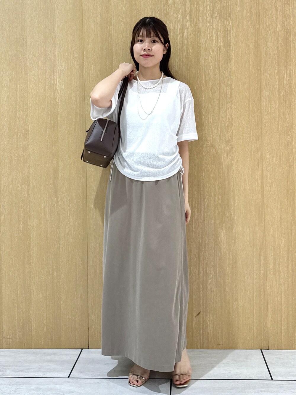 ホワイト系のTシャツ/カットソー、ホワイト系のタンクトップ、グリーン系のスカートを着用したレディースの夏コーディネートの2枚目の写真