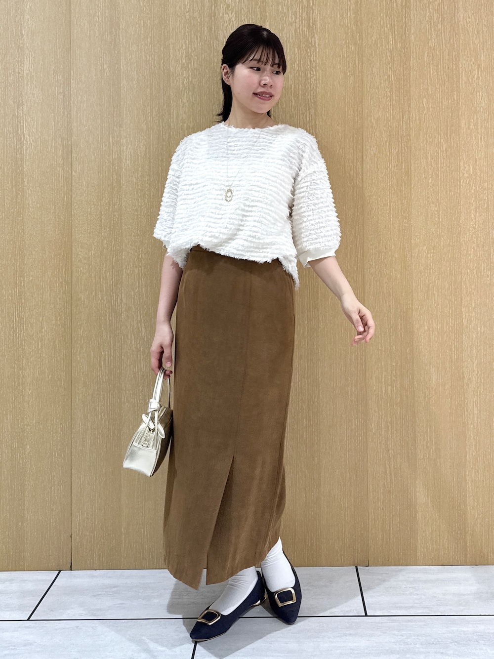 ホワイト系のTシャツ/カットソー、イエロー系のスカートを着用したレディースの秋コーディネートの9枚目の写真