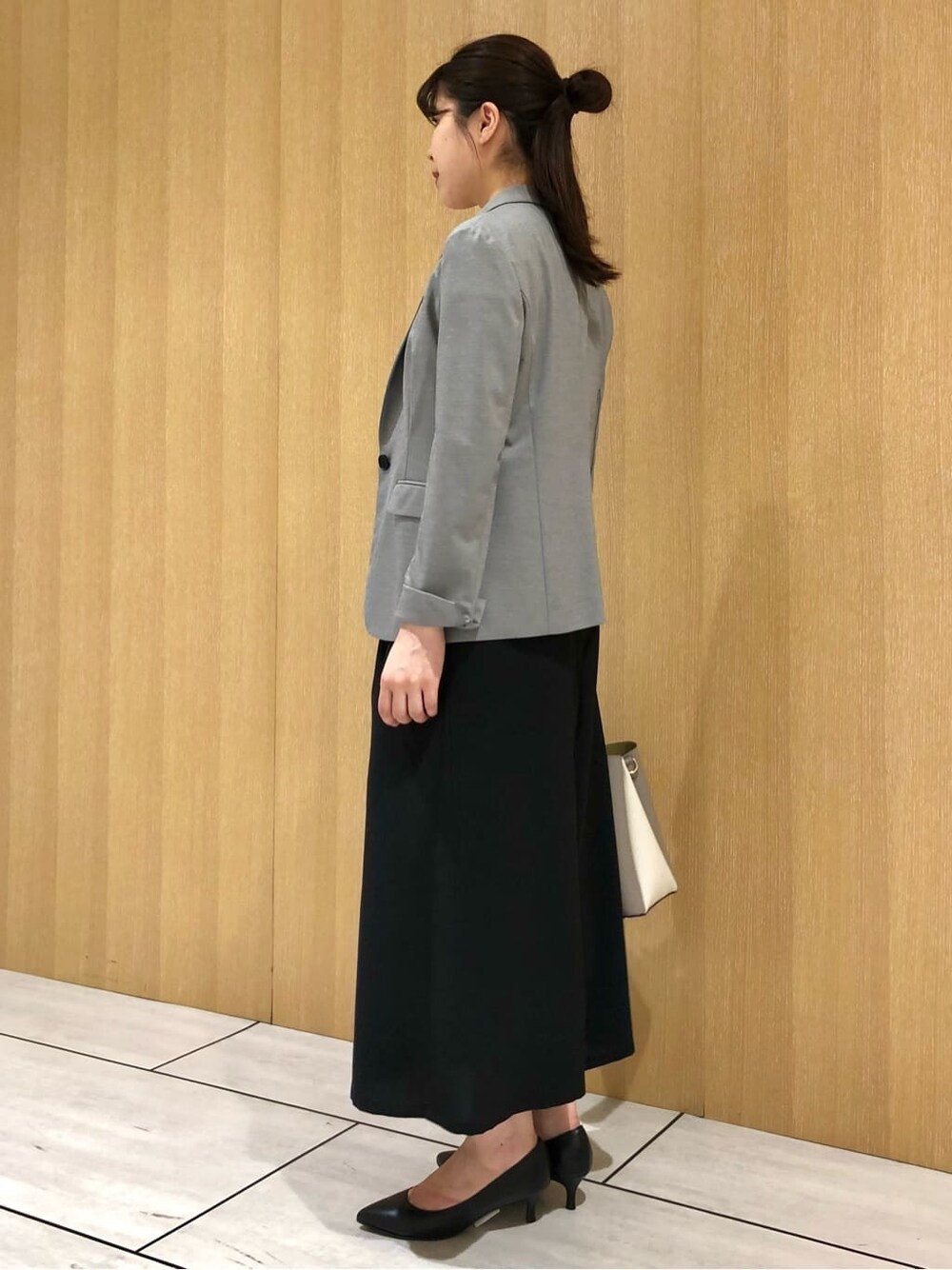 グレー系のテーラードジャケット、グレー系のシャツ/ブラウス、ブラック系のパンプスを着用したレディースの夏コーディネートの3枚目の写真