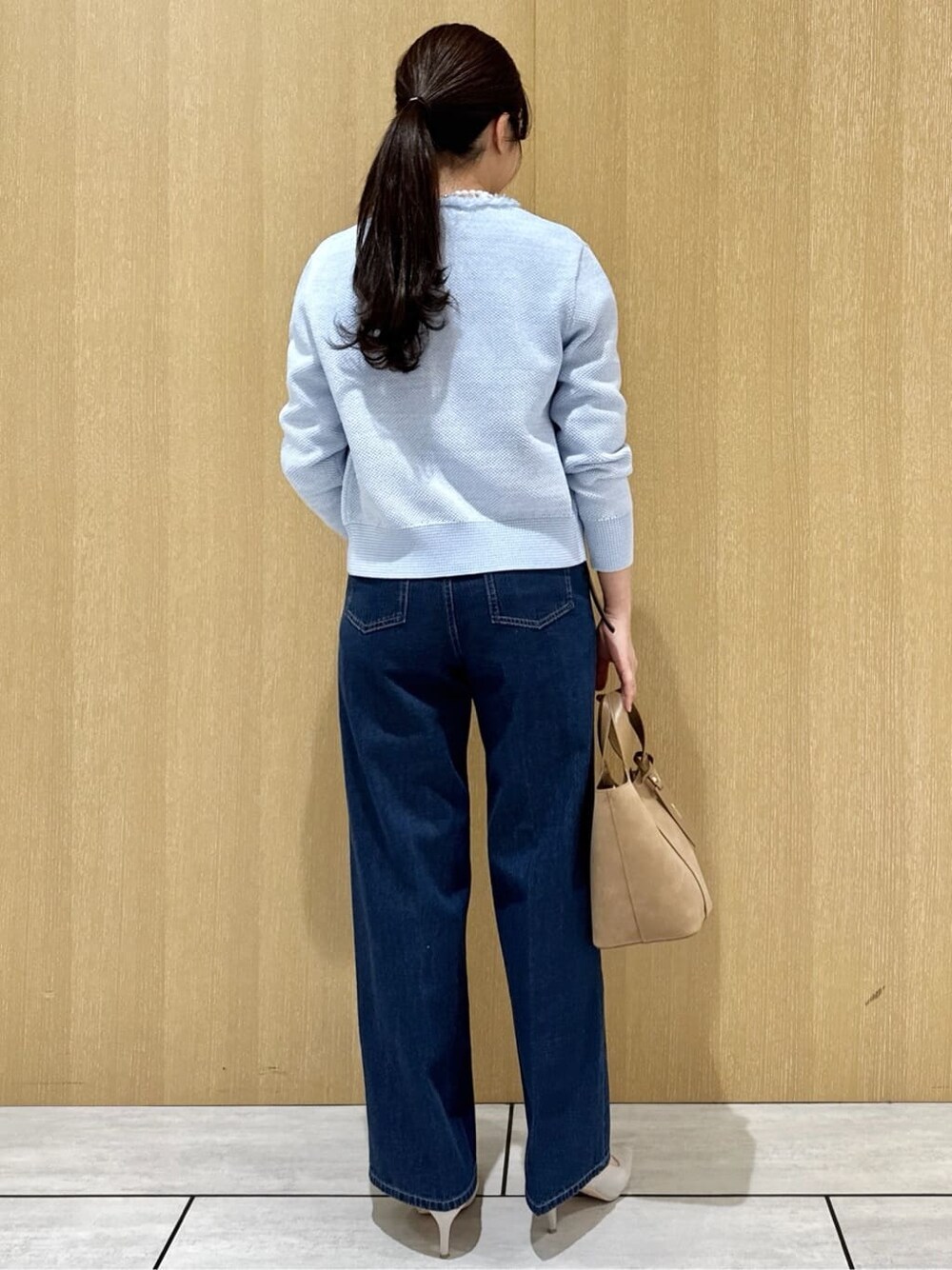 ベージュ系のトートバッグ、ブルー系のデニムパンツ、ホワイト系のシャツ/ブラウスを着用したレディースの春コーディネートの3枚目の写真