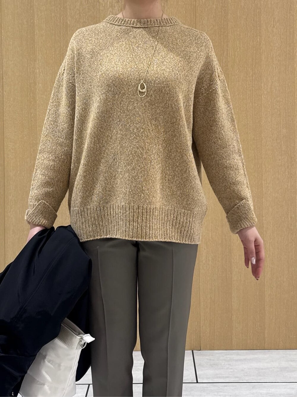 イエロー系のニット/セーター、ベージュ系のその他パンツ、ブラック系のブルゾンを着用したレディースの秋コーディネートの6枚目の写真