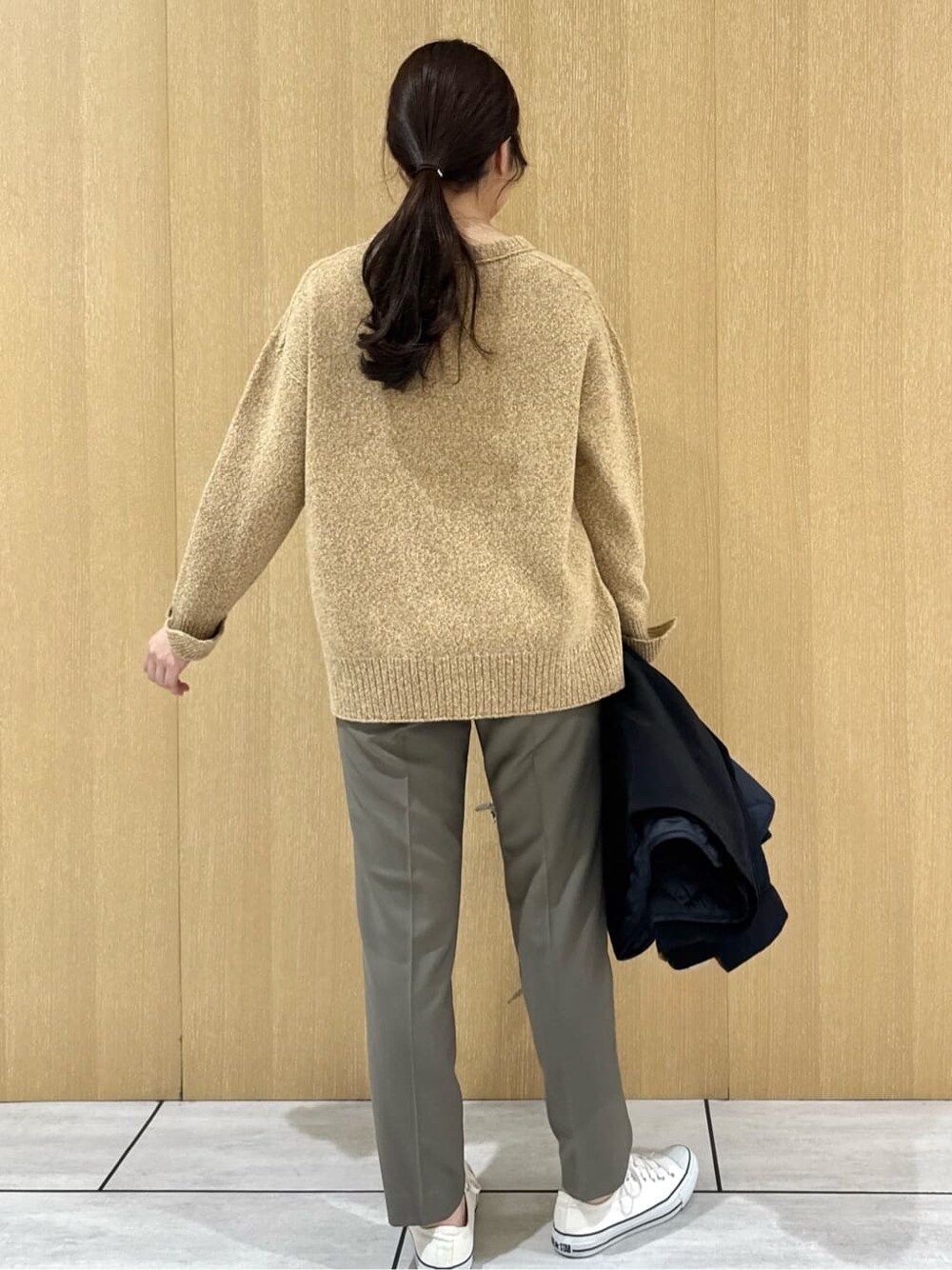 イエロー系のニット/セーター、ベージュ系のその他パンツ、ブラック系のブルゾンを着用したレディースの秋コーディネートの4枚目の写真