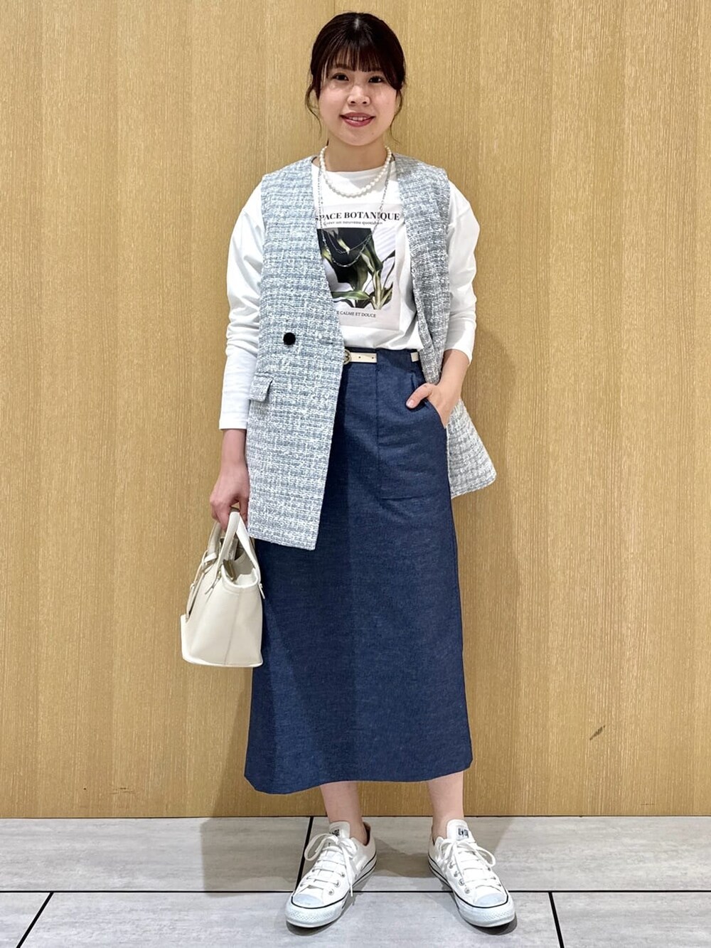 グレー系のブルゾン、ホワイト系のTシャツ/カットソー、ブルー系のスカートを着用したレディースの春コーディネートの6枚目の写真