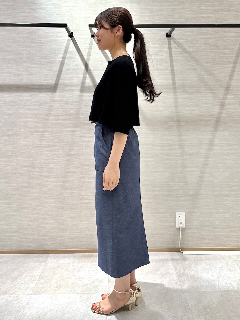 ブラック系のカーディガン/ボレロ、ブルー系のスカートを着用したレディースの夏コーディネートの2枚目の写真