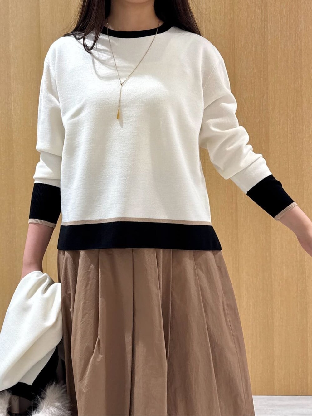 ホワイト系のニット/セーター、ホワイト系のカーディガン/ボレロ、イエロー系のスカートを着用したレディースの冬コーディネートの5枚目の写真