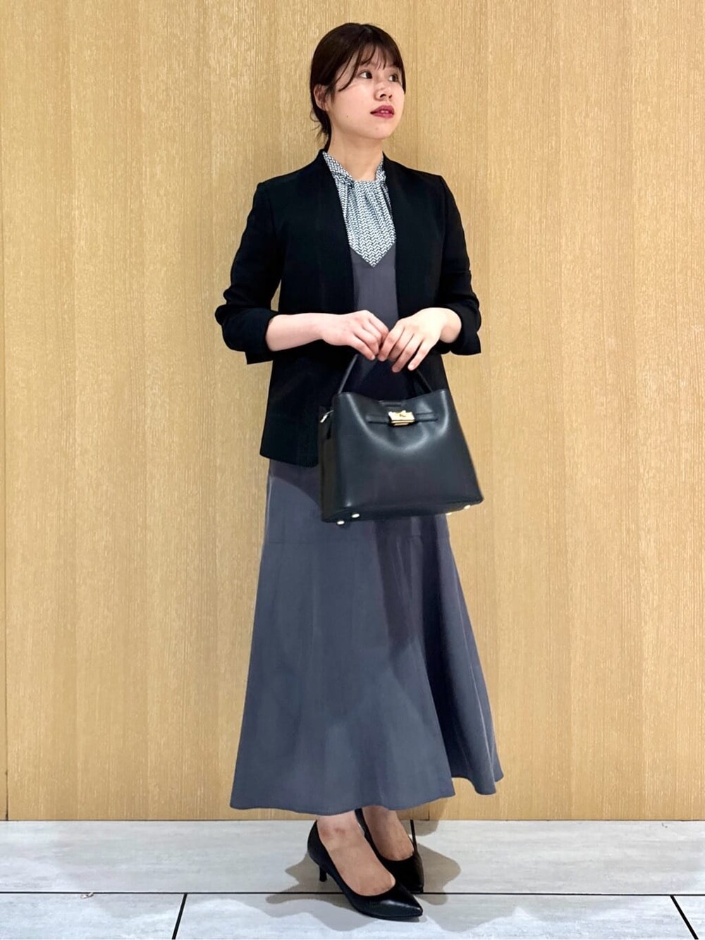ブラック系のノーカラージャケット、ブルー系のシャツ/ブラウス、グレー系のワンピースを着用したレディースの夏コーディネートの2枚目の写真