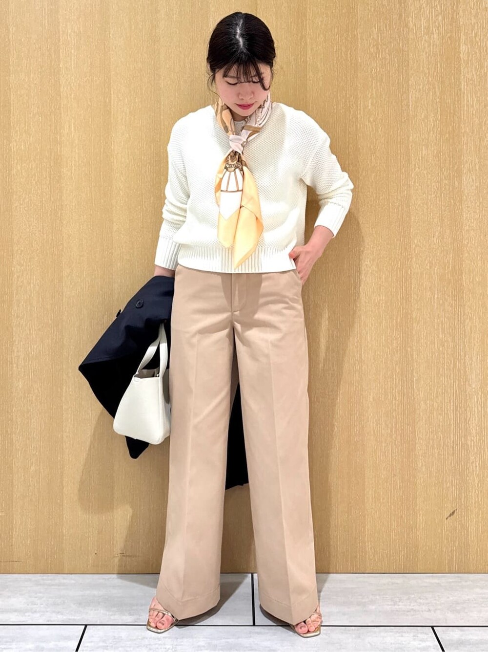 ホワイト系のニット/セーター、ベージュ系のその他パンツ、ブルー系のトレンチコートを着用したレディースの冬コーディネートの7枚目の写真