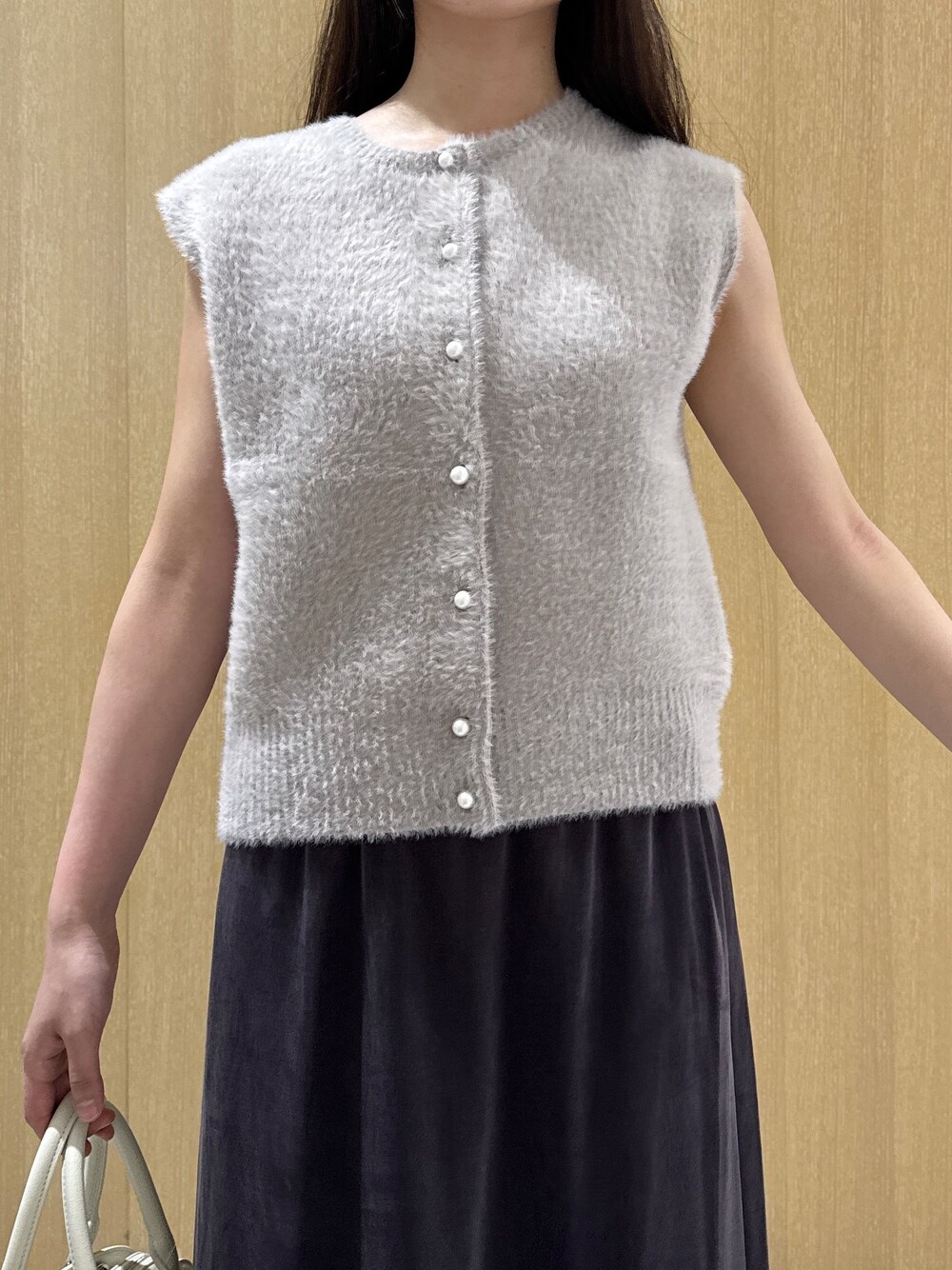 ベージュ系のカーディガン/ボレロ、ホワイト系のTシャツ/カットソー、ブラウン系のスカートを着用したレディースの秋コーディネートの6枚目の写真