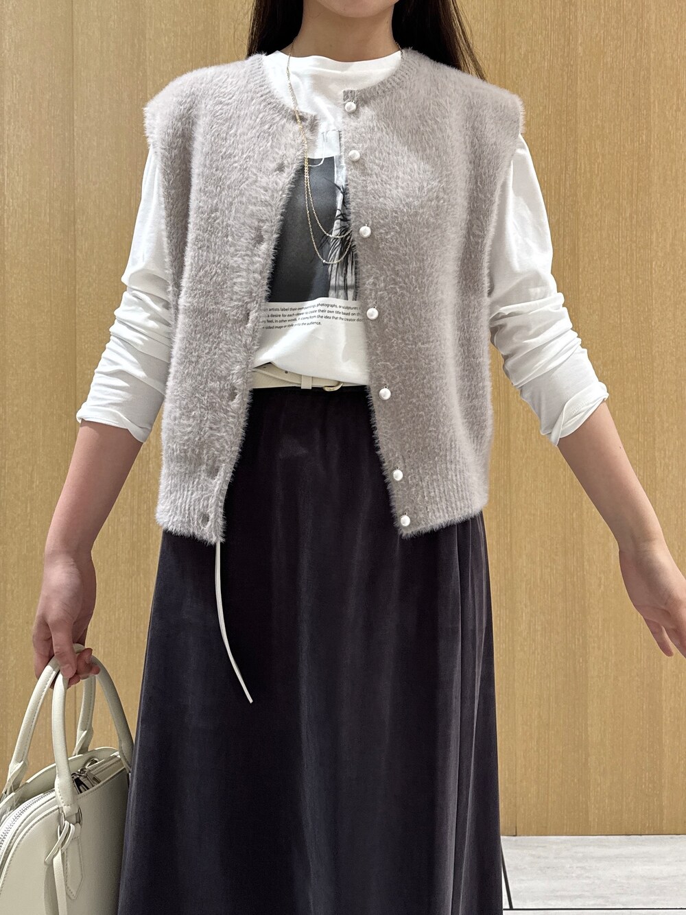 ベージュ系のカーディガン/ボレロ、ホワイト系のTシャツ/カットソー、ブラウン系のスカートを着用したレディースの秋コーディネートの6枚目の写真