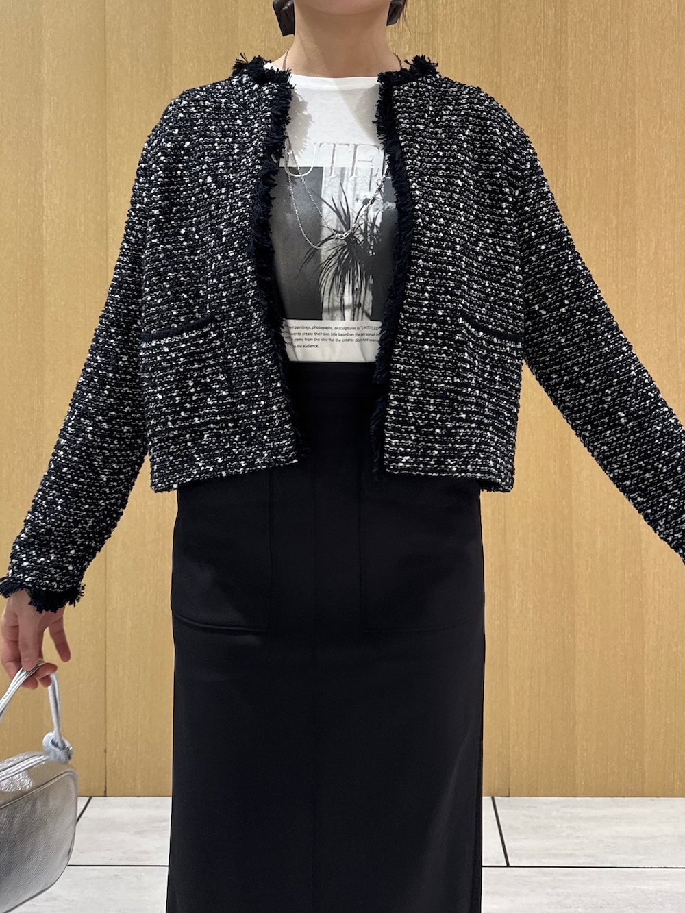 ブラック系のカーディガン/ボレロ、ホワイト系のTシャツ/カットソー、ブラック系のスカートを着用したレディースの秋コーディネートの6枚目の写真