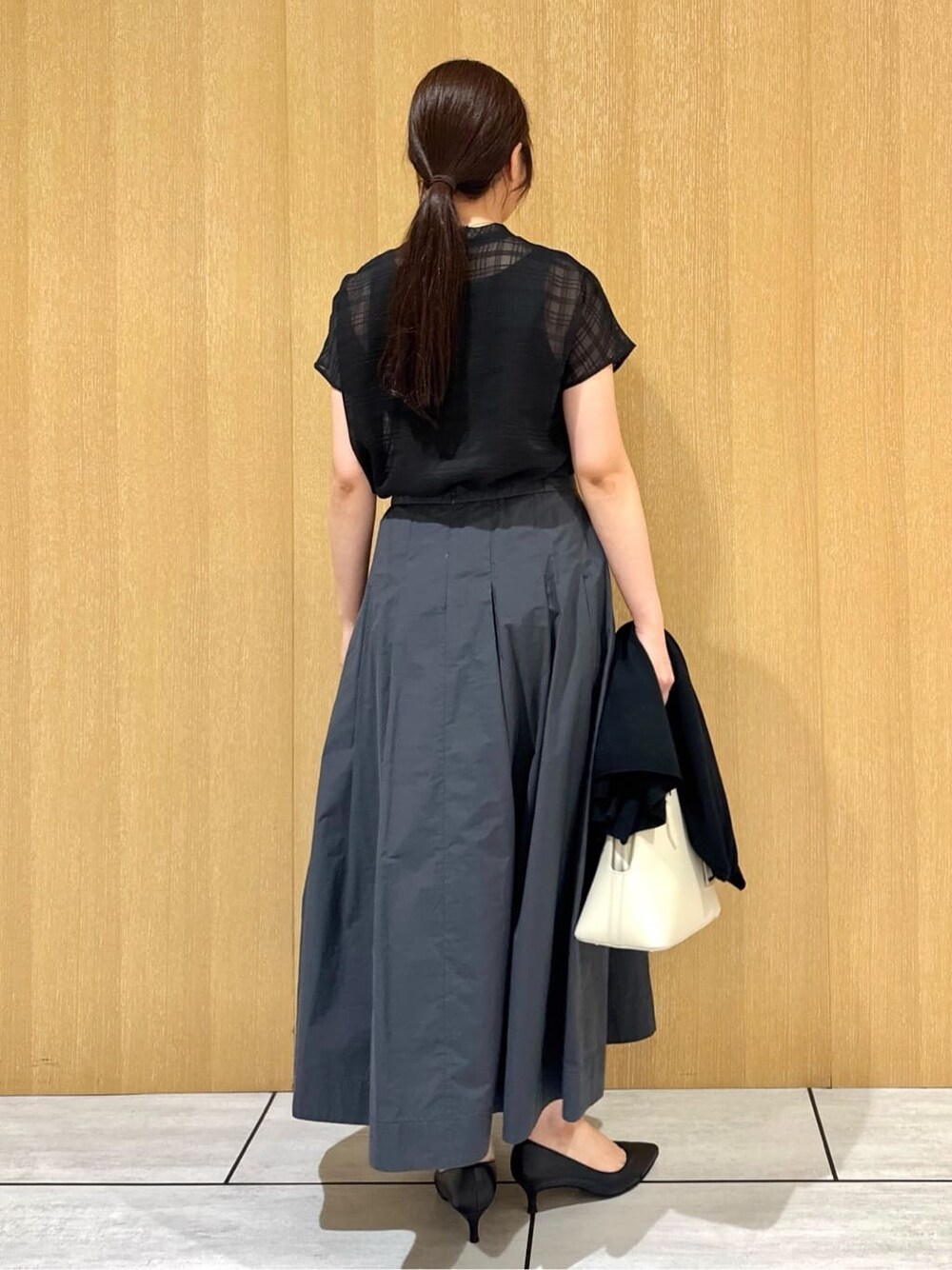ブラック系のシャツ/ブラウス、グレー系のスカート、ブラック系のカーディガン/ボレロを着用したレディースの秋コーディネートの4枚目の写真