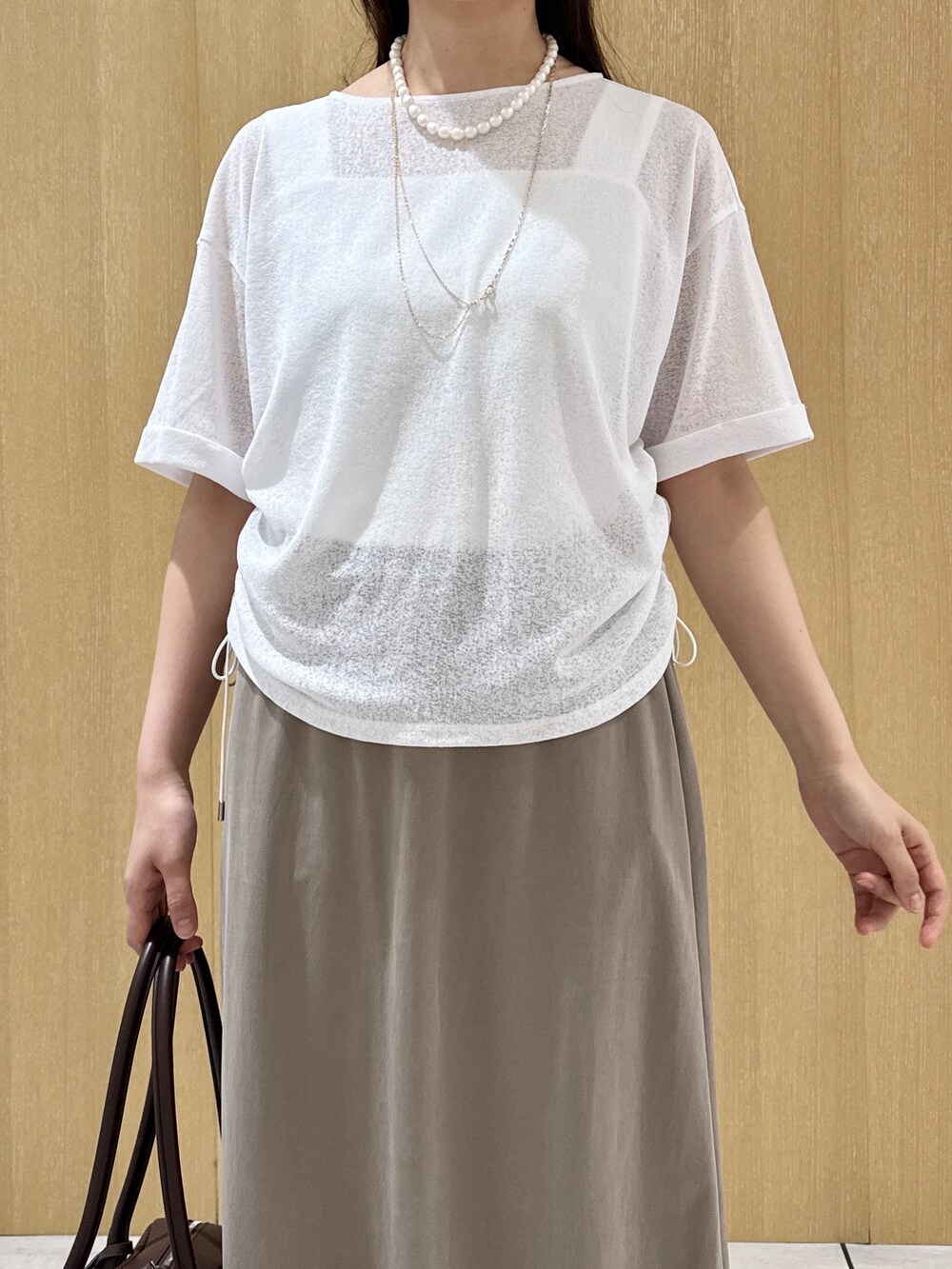 ホワイト系のTシャツ/カットソー、ホワイト系のタンクトップ、グリーン系のスカートを着用したレディースの夏コーディネートの6枚目の写真