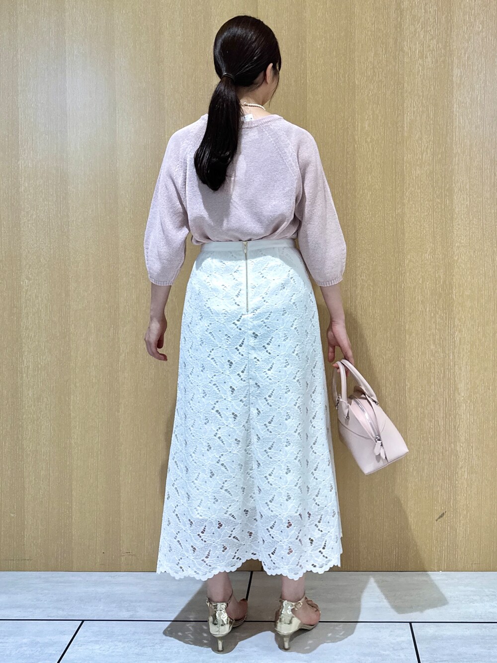 ピンク系のニット/セーター、ホワイト系のスカートを着用したレディースの夏コーディネートの4枚目の写真