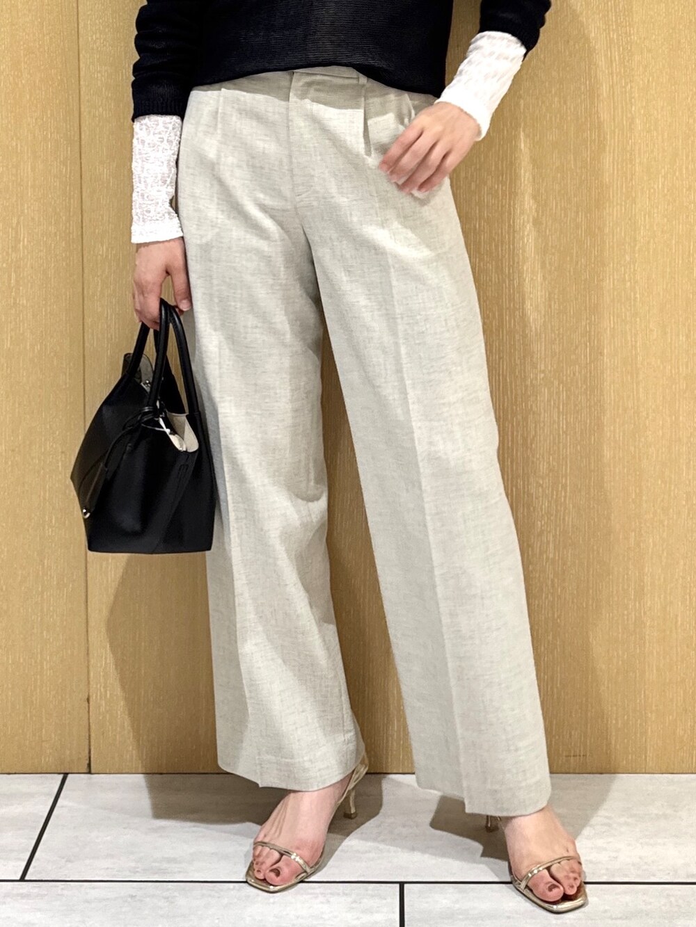 ブルー系のニット/セーター、ホワイト系のカーディガン/ボレロ、ベージュ系のその他パンツを着用したレディースの春コーディネートの6枚目の写真