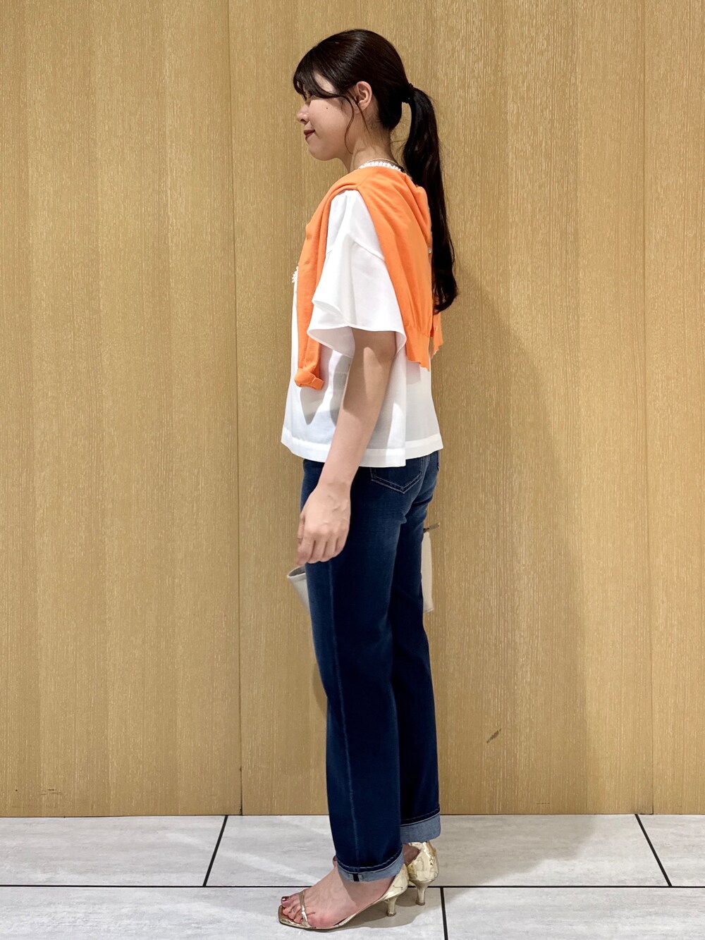 ホワイト系のシャツ/ブラウス、オレンジ系のカーディガン/ボレロ、ブルー系のデニムパンツを着用したレディースの夏コーディネートの2枚目の写真