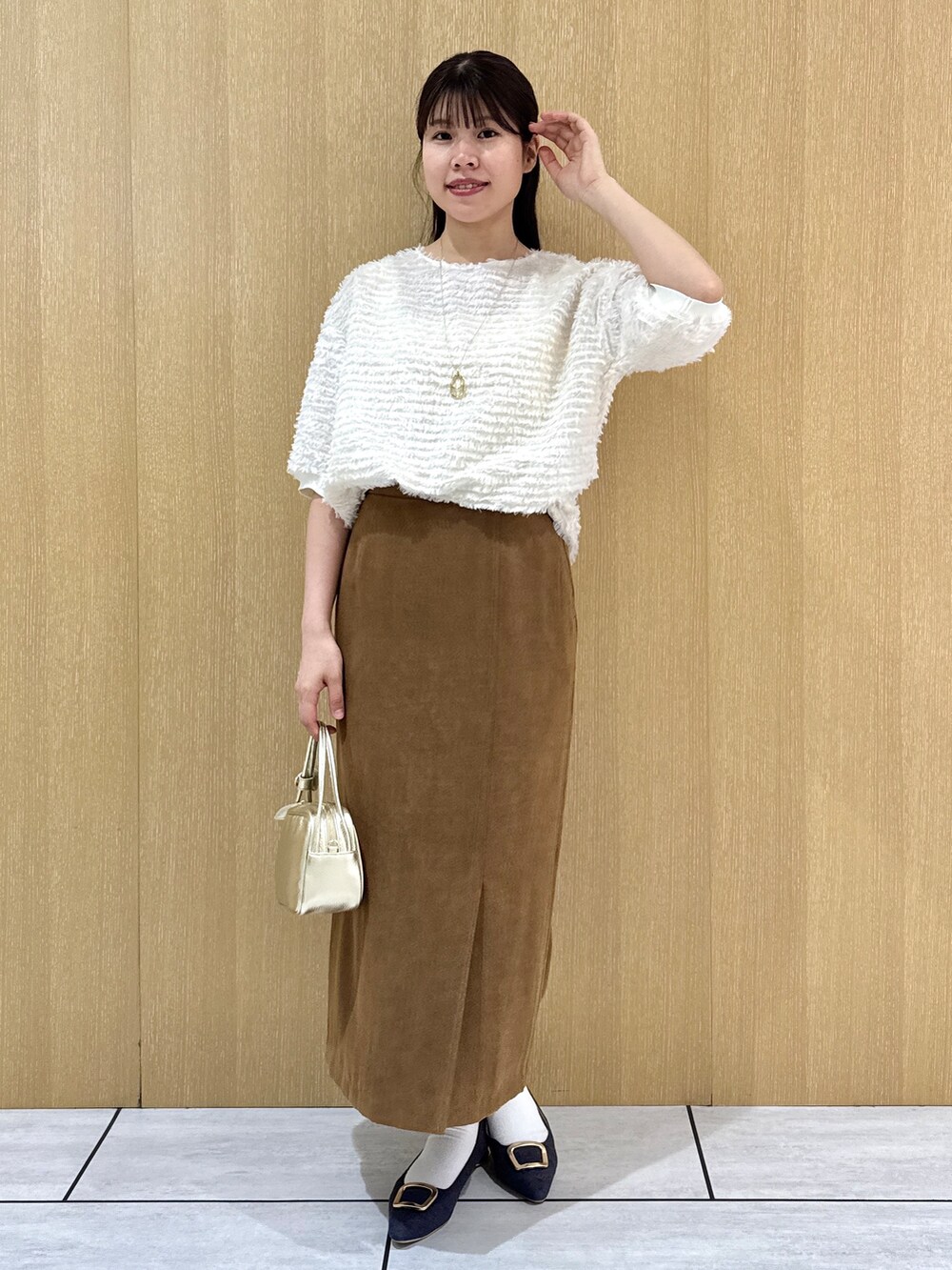 ホワイト系のTシャツ/カットソー、イエロー系のスカートを着用したレディースの秋コーディネートの6枚目の写真
