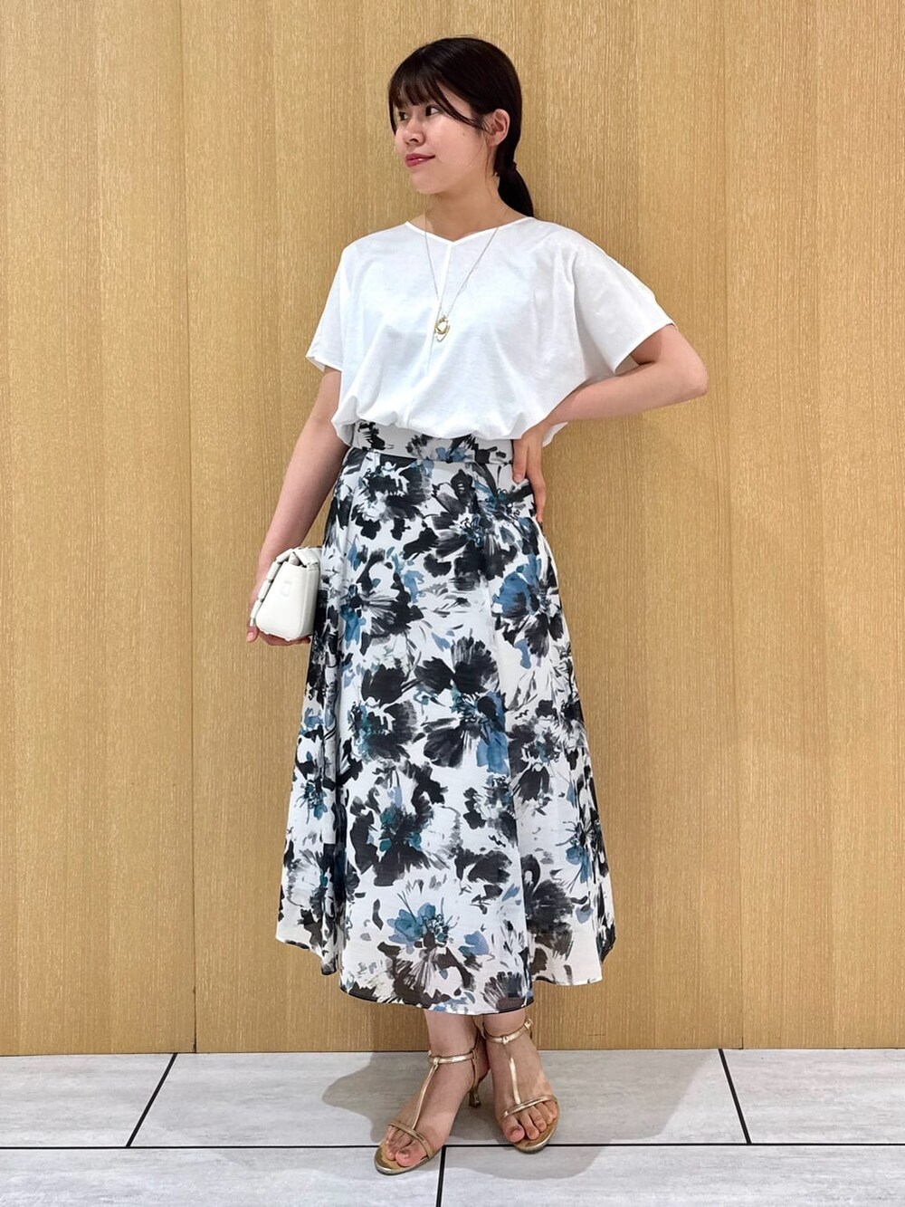 ホワイト系のTシャツ/カットソー、ブルー系のスカートを着用したレディースの秋コーディネートの2枚目の写真