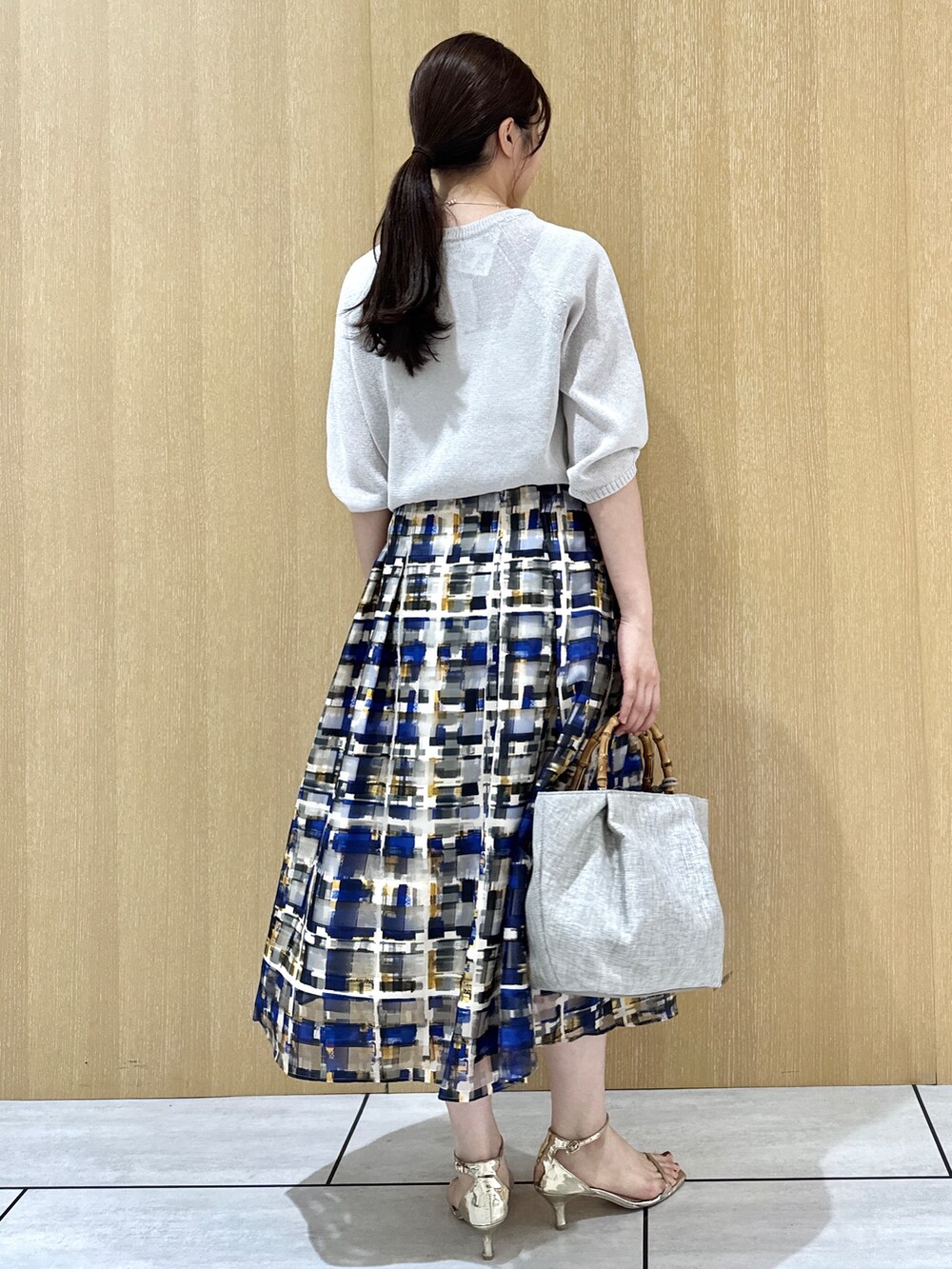 グレー系のニット/セーター、ホワイト系のタンクトップを着用したレディースの夏コーディネートの3枚目の写真