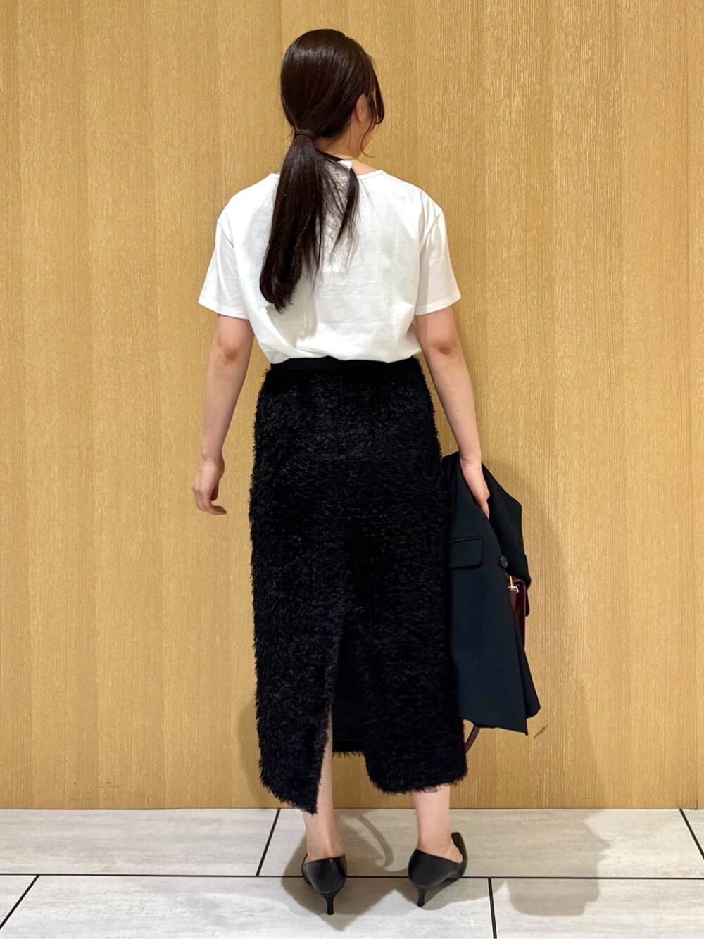 ブラック系のベスト、ホワイト系のTシャツ/カットソー、ブラウン系のスカートを着用したレディースの夏コーディネートの4枚目の写真