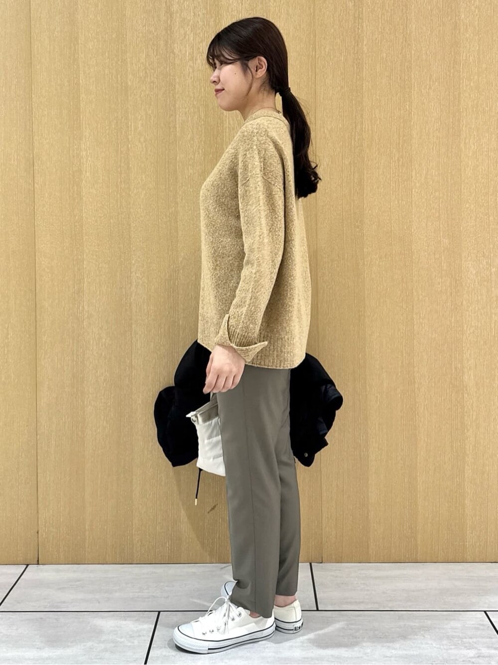 イエロー系のニット/セーター、ベージュ系のその他パンツ、ブラック系のブルゾンを着用したレディースの秋コーディネートの3枚目の写真