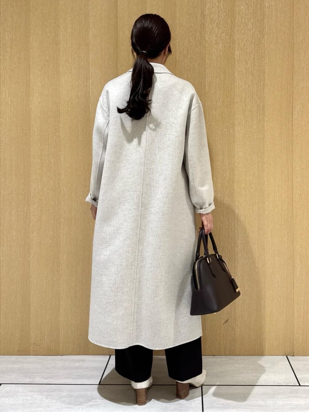 ブルー系のニット/セーター、ブラウン系のその他パンツ、ベージュ系のチェスターコートを着用したレディースの冬コーディネートの9枚目の写真