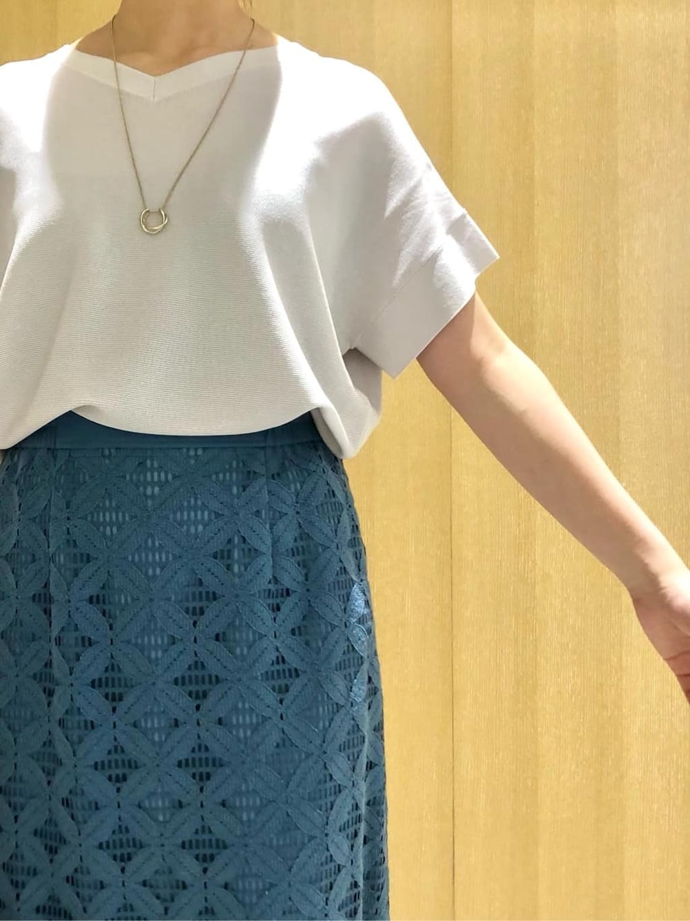 グレー系のニット/セーター、ブルー系のスカートを着用したレディースの夏コーディネートの4枚目の写真