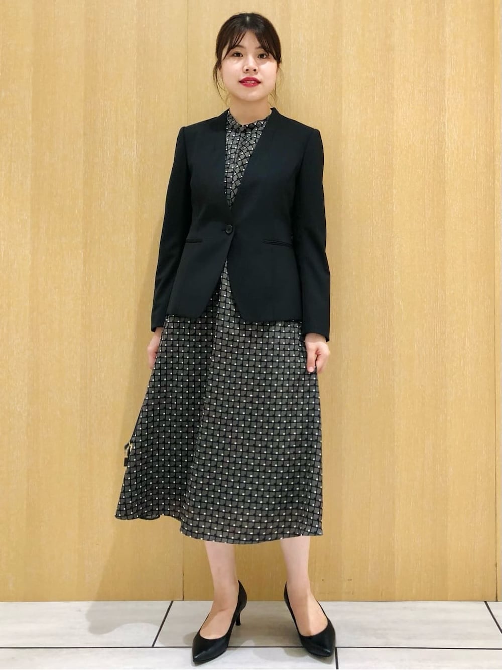 ブラック系のノーカラージャケット、ブラック系のパンプスを着用したレディースの夏コーディネートの3枚目の写真