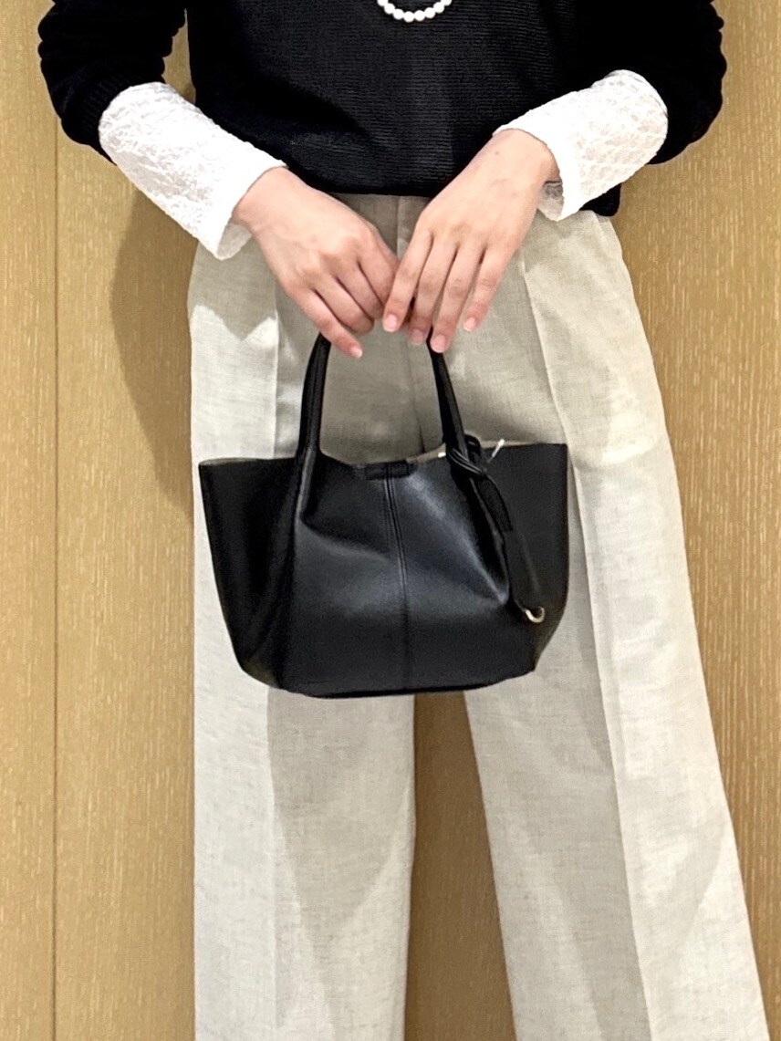 ブルー系のニット/セーター、ホワイト系のカーディガン/ボレロ、ベージュ系のその他パンツを着用したレディースの春コーディネートの7枚目の写真