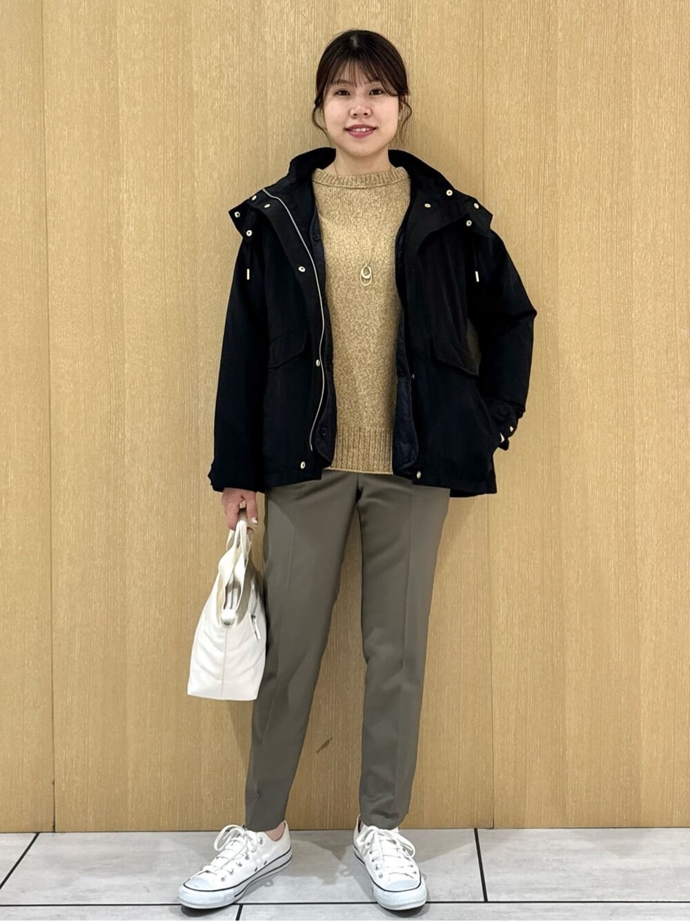 イエロー系のニット/セーター、ベージュ系のその他パンツ、ブラック系のブルゾンを着用したレディースの秋コーディネートの9枚目の写真