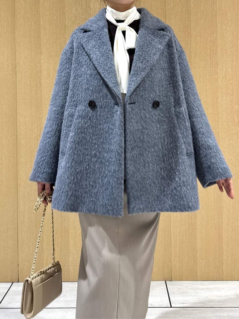 ブルー系のピーコート、ホワイト系のシャツ/ブラウス、ブラウン系のニット/セーターを着用したレディースの冬コーディネートの5枚目の写真