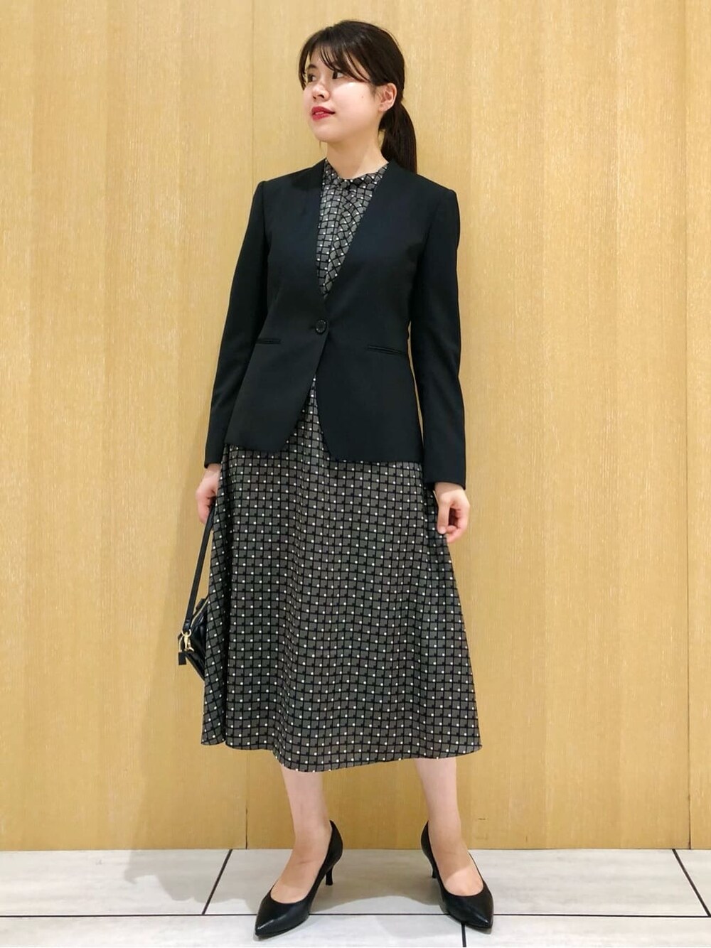 ブラック系のノーカラージャケット、ブラック系のパンプスを着用したレディースの夏コーディネートの2枚目の写真
