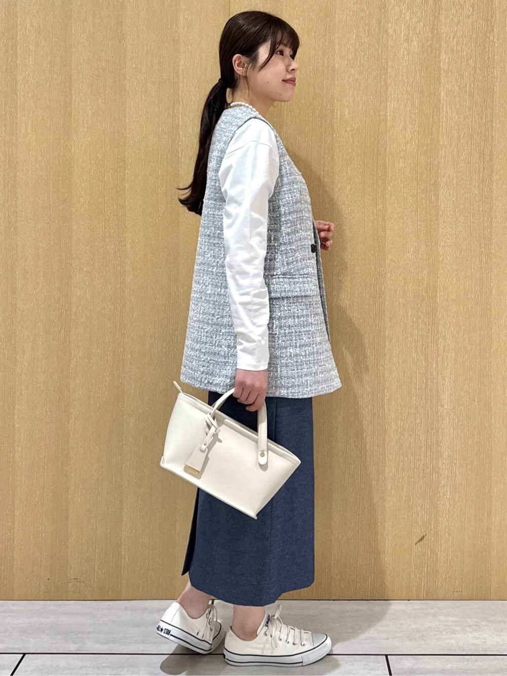 グレー系のブルゾン、ホワイト系のTシャツ/カットソー、ブルー系のスカートを着用したレディースの春コーディネートの4枚目の写真